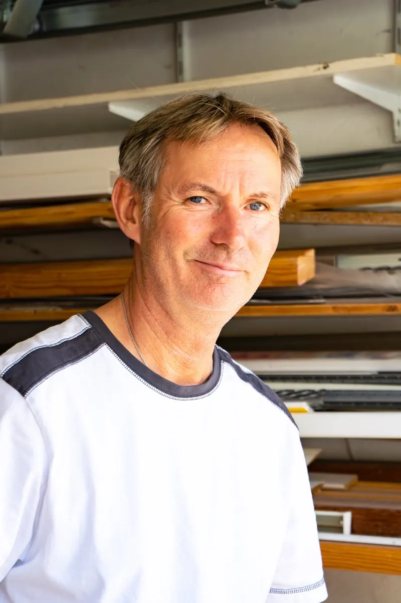 Gerold Brose in seiner Werkstatt vor einem Materialregal
